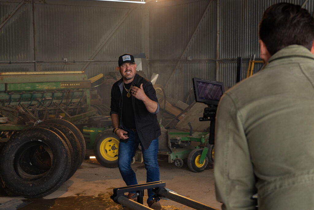 Behind the scenes filming of artist performance inside barn with cinema camera and slider