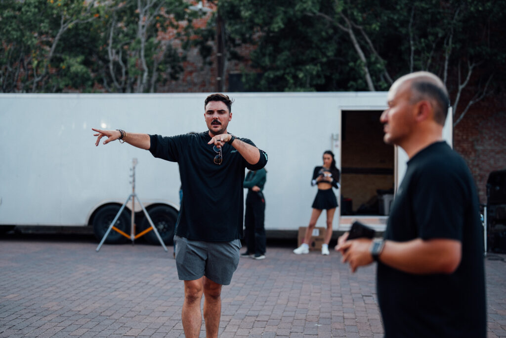 Director giving direction to crew during outdoor video production shoot