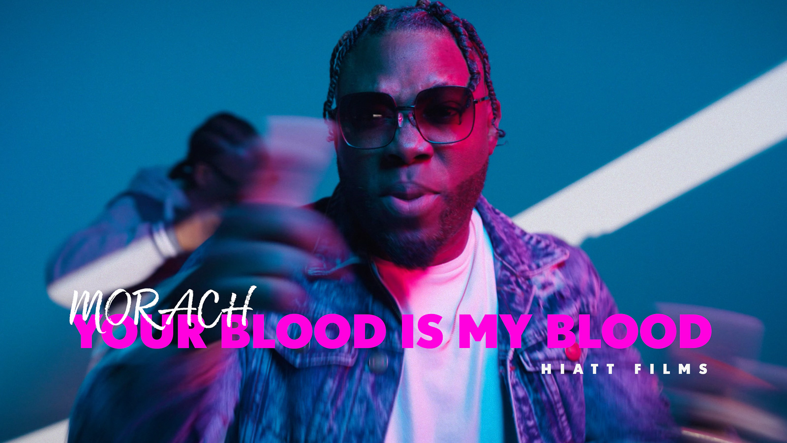 Music video thumbnail featuring an artist performing under blue and pink studio lighting