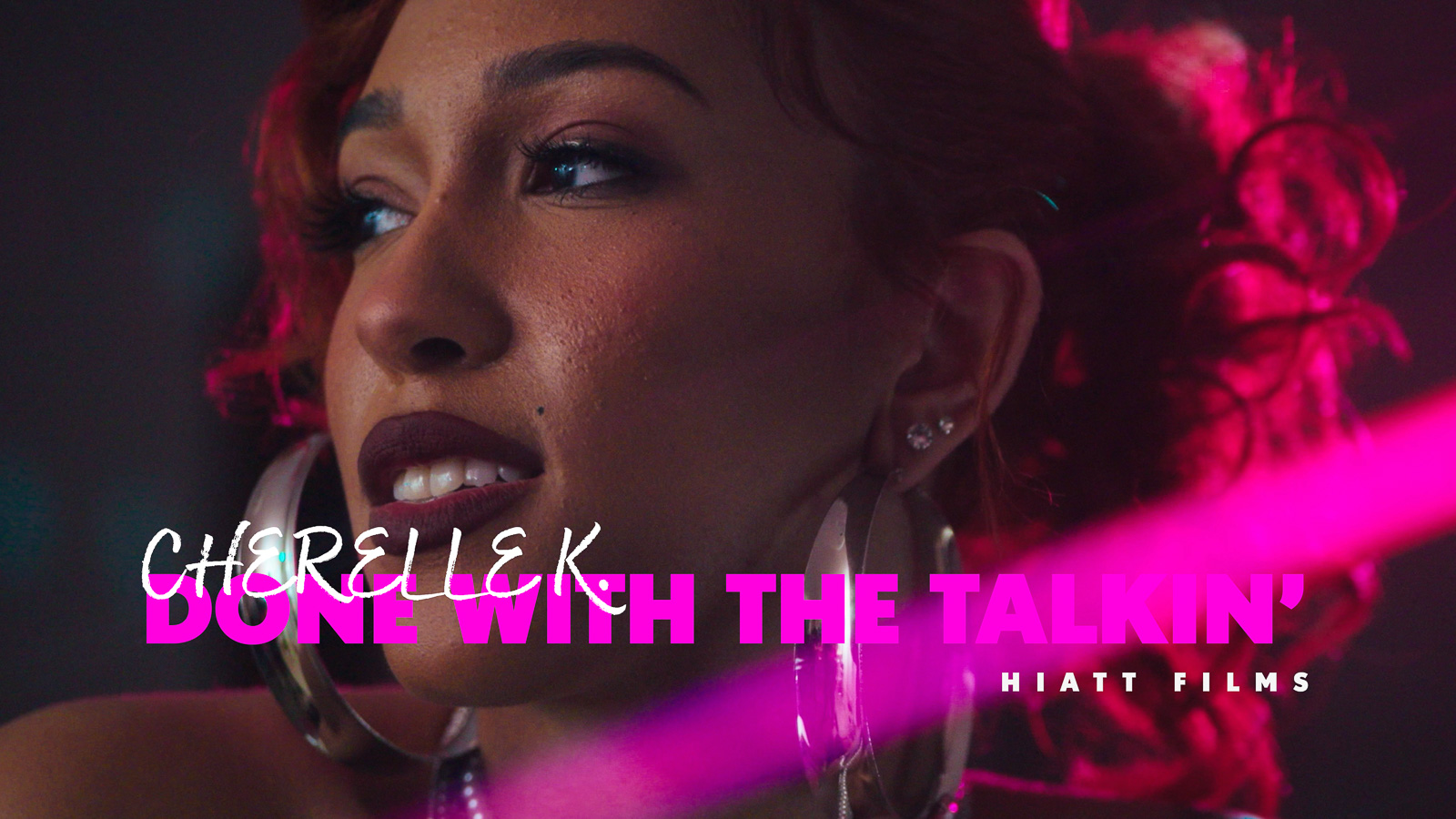 Music video thumbnail featuring a close-up portrait of an artist under pink cinematic lighting