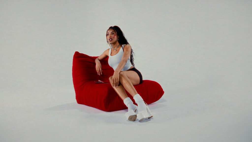 Studio video production featuring talent seated on red chair against minimal backdrop