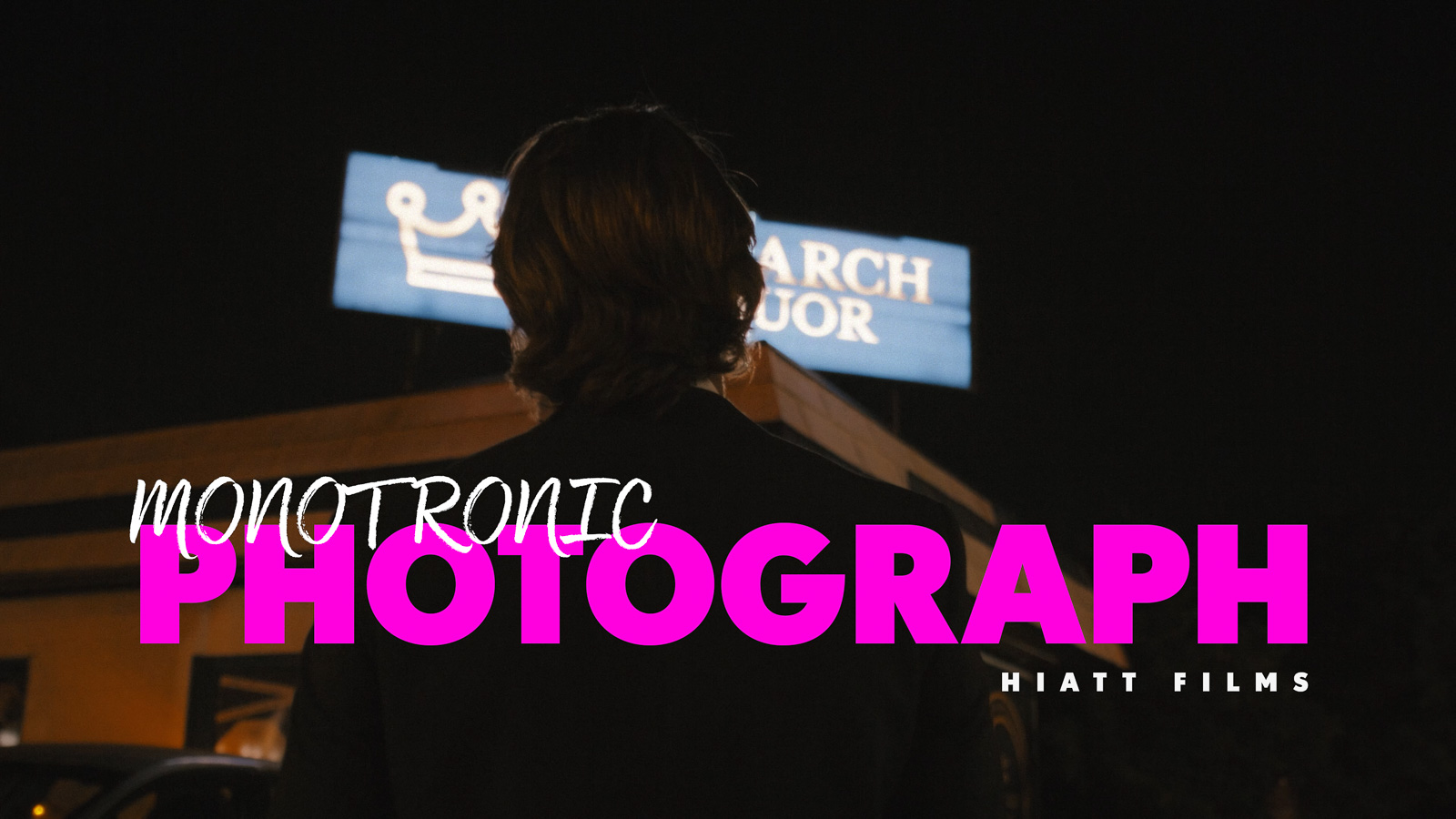 Moody cinematic night scene showing a man viewed from behind under neon signage, filmed by Hiatt Films