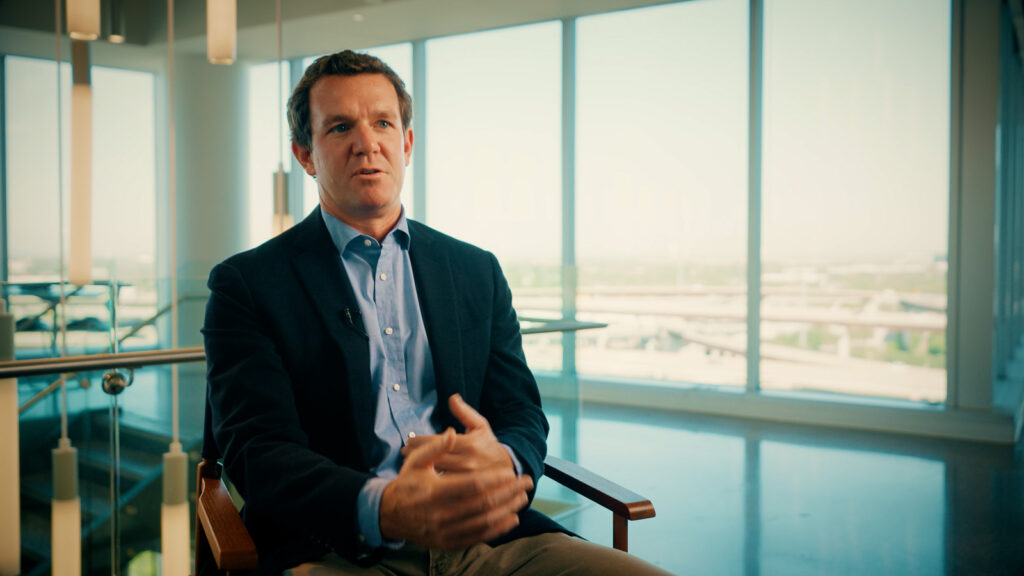 Cinematic interview scene showing a man speaking on camera in a modern office environment, filmed by Hiatt Films