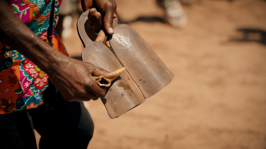 Cinematic close-up of hands holding a traditional percussion instrument outdoors, filmed by Hiatt Films