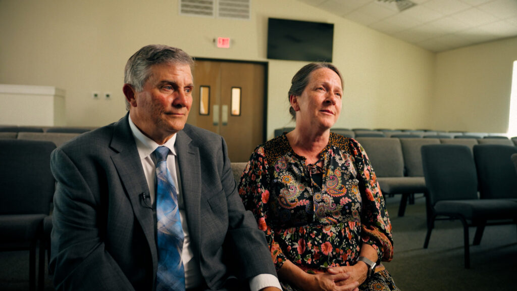 Man and woman seated in church auditorium giving interview testimonial